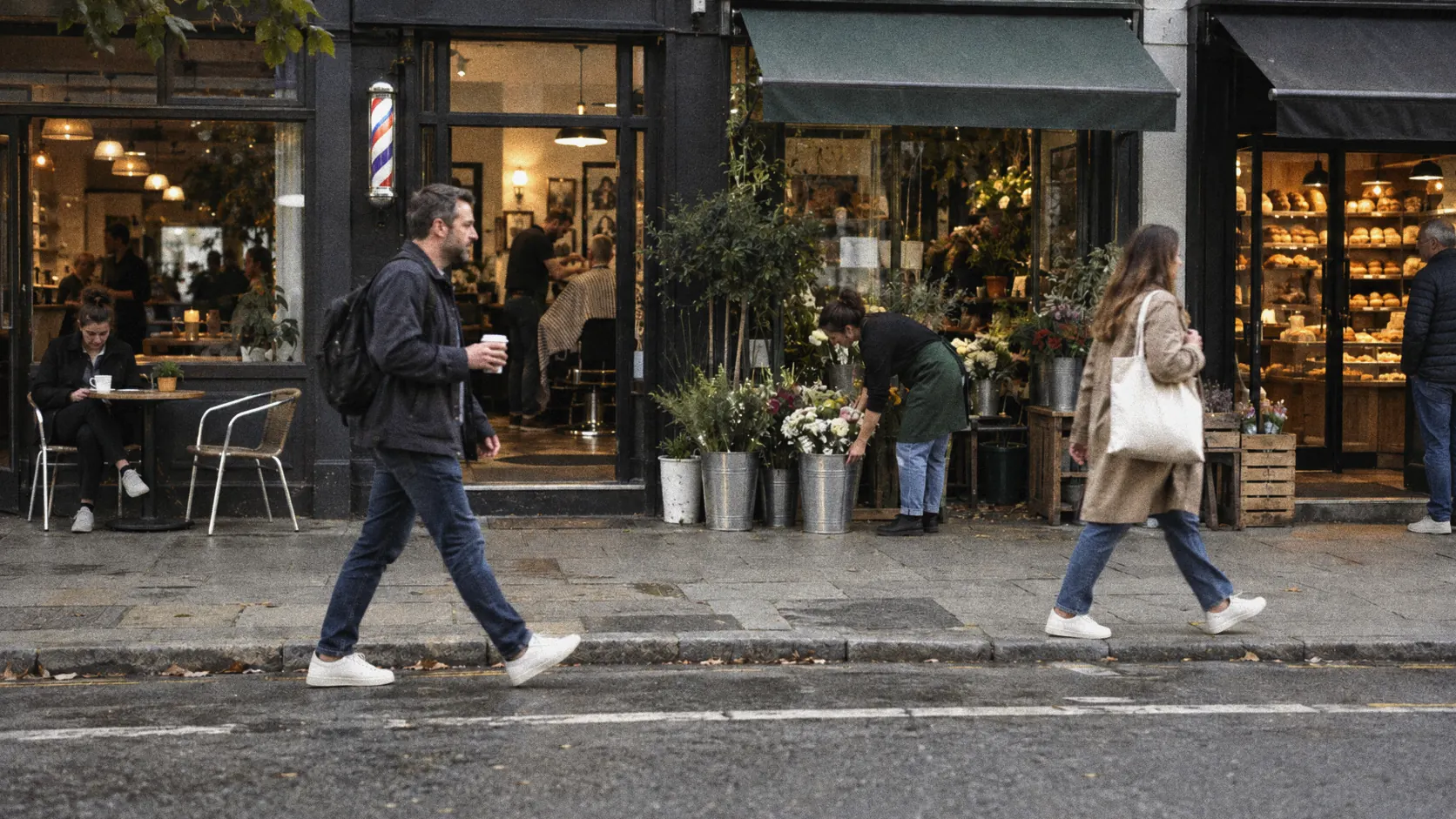 A row of small independent shops on a high street in the morning, with people passing.